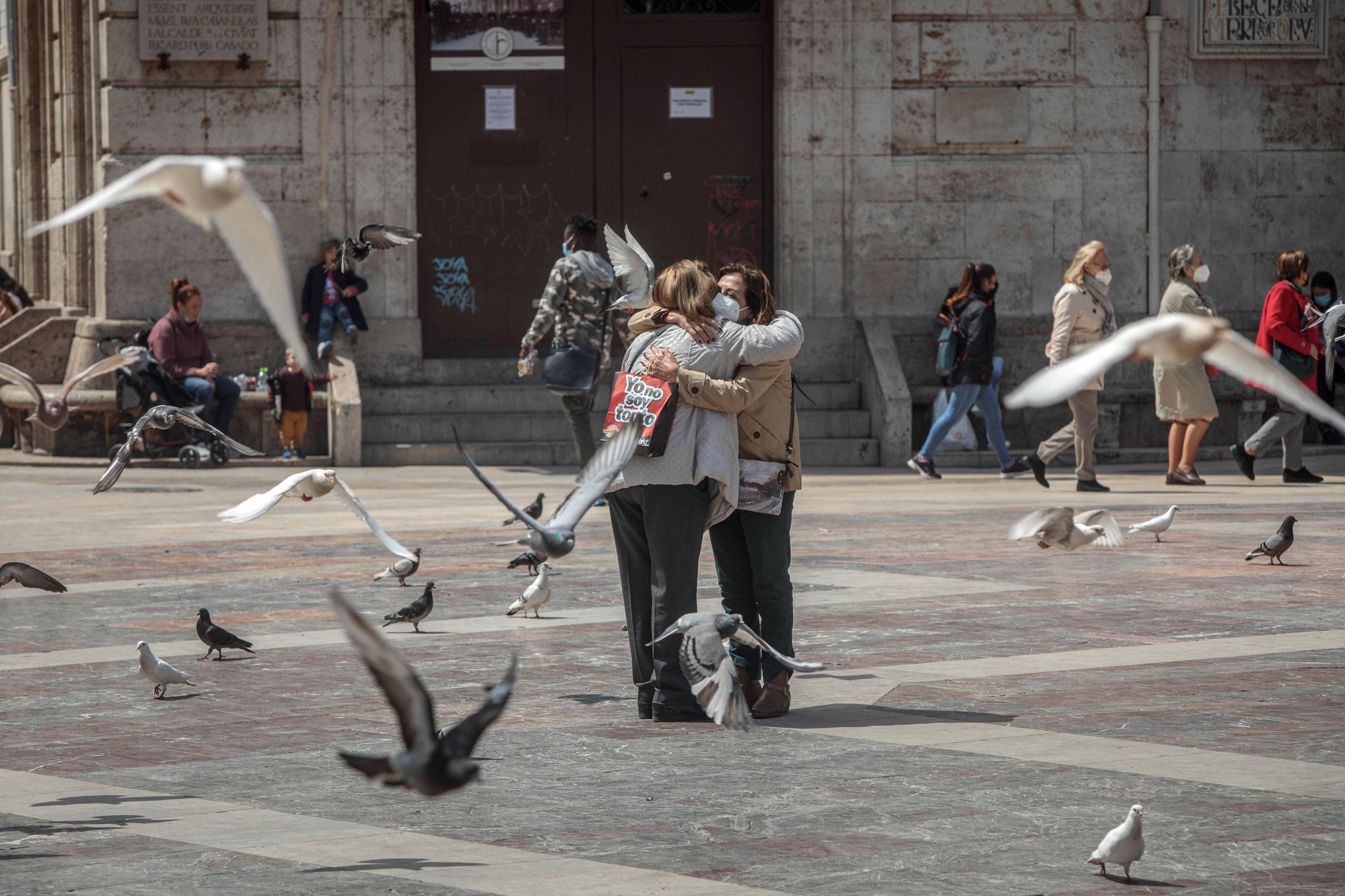Dos mujeres se abrazan en una céntrica plaza de Valencia, un gesto difícil de ver durante la pandemia, pero que se va recuperando a medida que avanza el proceso de vacunación